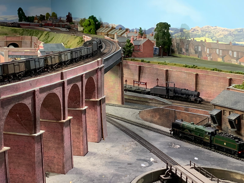 Goods train crossing viaduct over loco depot